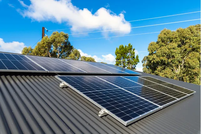 Commercial solar panels on a rooftop against a cloudy sky